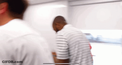 Man In Striped Shirt Standing In Room GIF