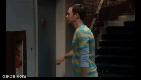 Man In Striped Shirt Standing Next To Door And Stairs GIF