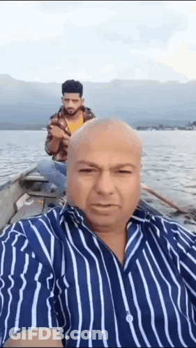 Man In Striped Shirt Taking Selfie On Boat GIF