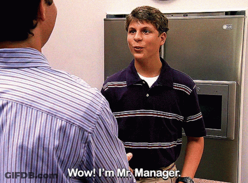 Man In Striped Shirt Talking To Another Man In Front Of LG Refrigerator GIF