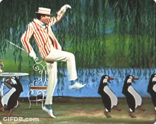Man In Striped Suit Jumping And Dancing With Penguins GIF