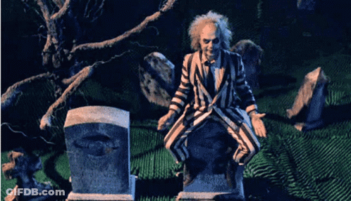 Man In Striped Suit Sitting On Grave GIF
