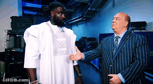 Man In Striped Suit Talks To Man In White Shirt GIF