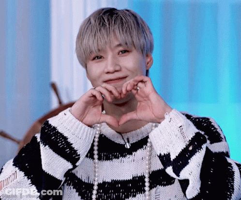 Man In Striped Sweater And Pearls Making Heart Shape GIF