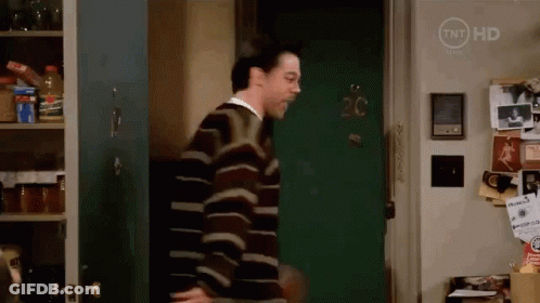 Man In Striped Sweater In Front Of Door Number 20 GIF