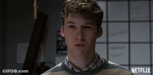 Man In Striped Sweater In Front Of Netflix Board GIF