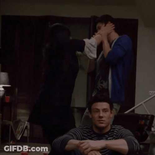 Man In Striped Sweater Sitting On Couch GIF