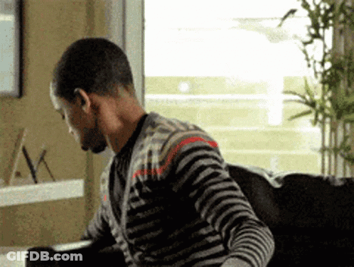 Man In Striped Sweater Sitting On Couch In Front Of Window GIF