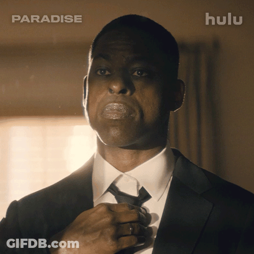 Man In Suit Adjusting Tie In Front Of Hulu Ad GIF