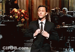 Man In Suit Adjusting Tie On Stage GIF