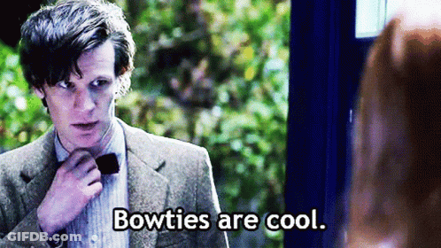 Man In Suit Adjusts Bow Tie Woman Says Bowties Are Cool GIF