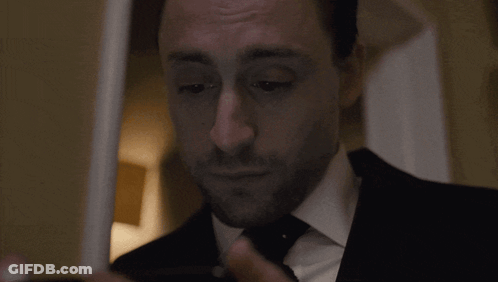 Man In Suit Adjusts Tie Before Mirror GIF