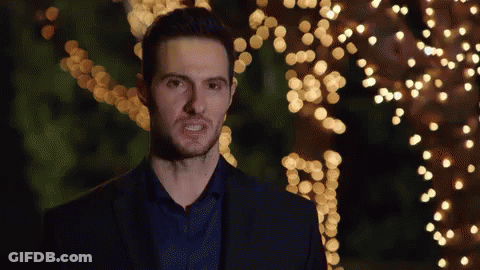 Man In Suit And Blue Shirt In Front Of Christmas Tree GIF