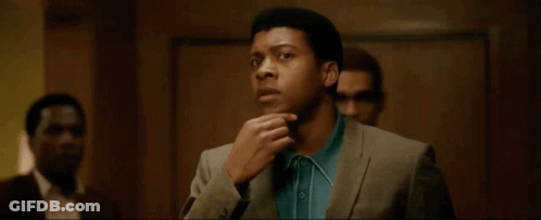 Man In Suit And Blue Shirt Standing With Others GIF
