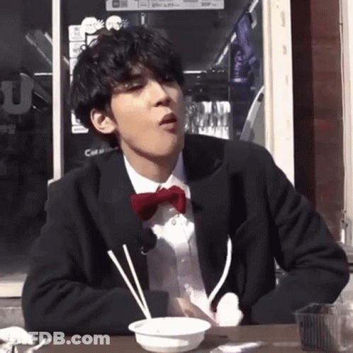 Man In Suit And Bow Tie Eating GIF