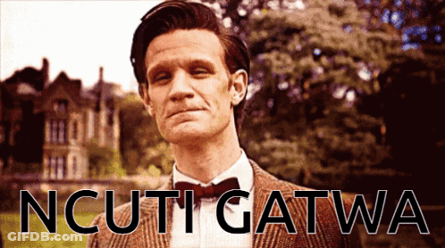 Man In Suit And Bow Tie In Front Of Ncuti Gatwa Sign GIF