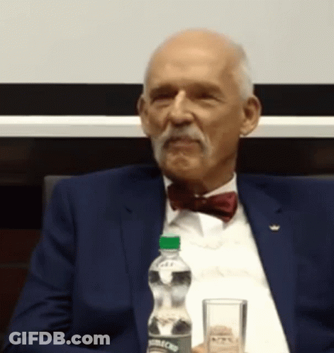 Man In Suit And Bow Tie Sitting At Table With Aquafina Water GIF