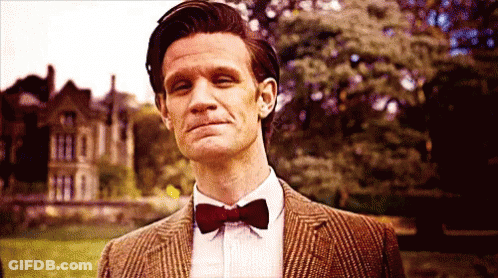 Man In Suit And Bow Tie Standing In Field GIF