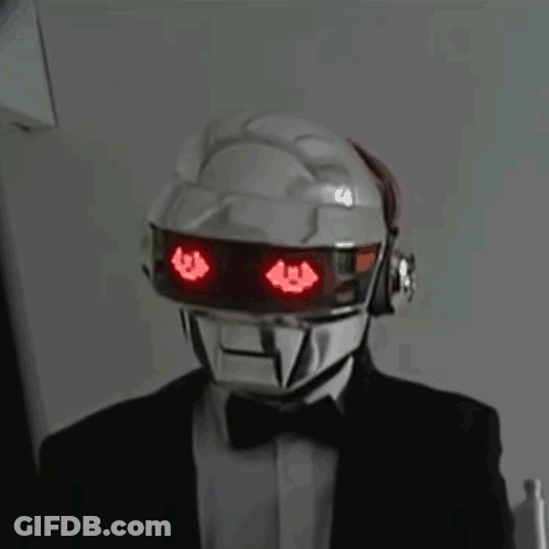 Man In Suit And Bow Tie With Red-Eyed Robot Helmet GIF