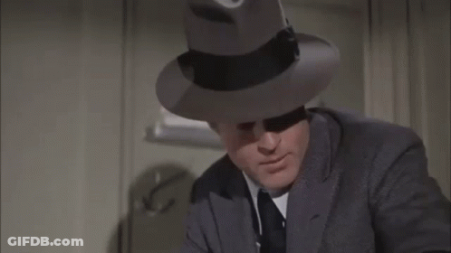 Man In Suit And Fedora Making Funny Face GIF