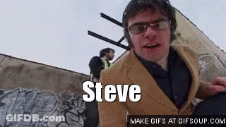 Man In Suit And Glasses Beside Steve Wall GIF