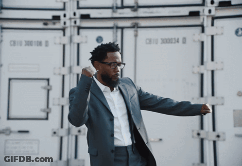 Man In Suit And Glasses In Front Of Cargo Container GIF
