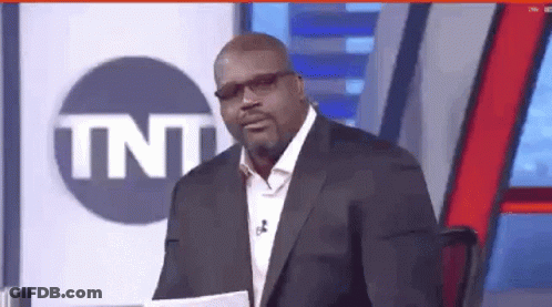 Man In Suit And Glasses In Front Of TNT Sign GIF
