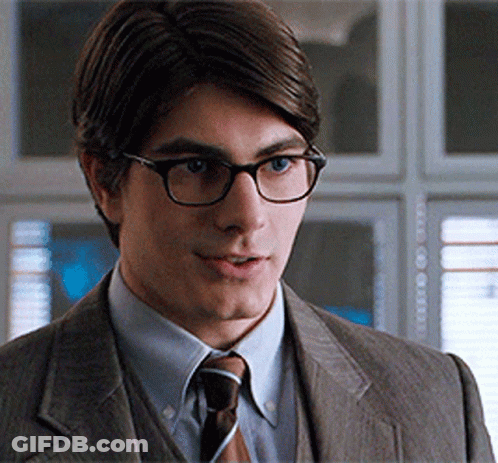 Man In Suit And Glasses Looks At Camera GIF