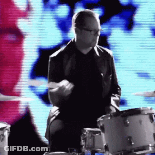 Man In Suit And Glasses Playing Drums GIF