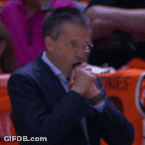 Man In Suit And Glasses Sits With Woman In Orange ACG Shirt GIF