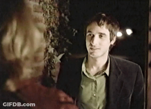 Man In Suit And Green Shirt In Front Of Brick Wall GIF