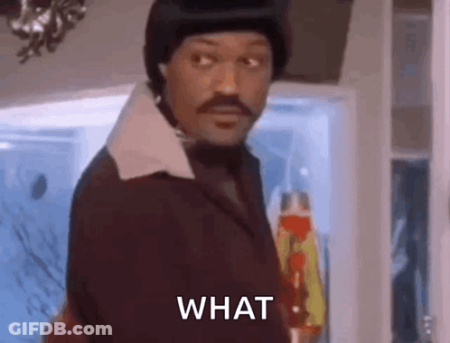 Man In Suit And Hat Asking What In Front Of Refrigerator GIF