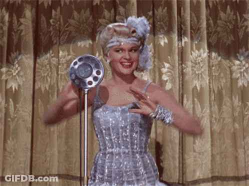 Man In Suit And Hat Dancing By Ahout Sign GIF