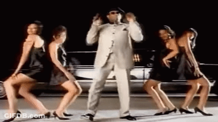 Man In Suit And Hat Dancing With Three Women In Black Dresses In Front Of A Car GIF