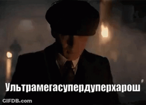 Man In Suit And Hat In Dark Room With Foreign Language GIF