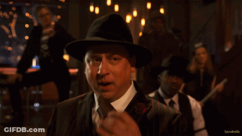Man In Suit And Hat In Front Of Sandroella Sign GIF