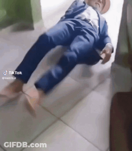 Man In Suit And Hat Laying On Floor With TikTok Watermark GIF