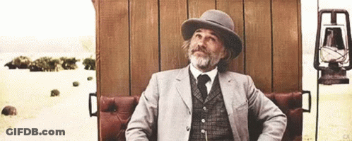 Man In Suit And Hat Sitting On Chair GIF