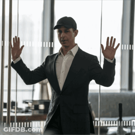 Man In Suit And Hat Standing In Front Of Glass Wall GIF