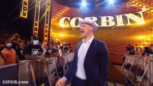Man In Suit And Hat Standing In Front Of Stage With Corbin GIF
