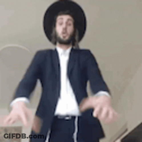 Man In Suit And Hat Standing With Hands Outstretched GIF