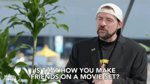 Man In Suit And Hat Talking About Making Friends On Movie Set GIF