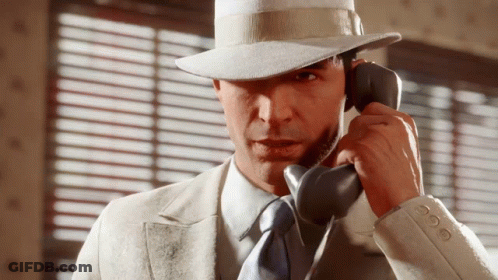 Man In Suit And Hat Talking On Phone GIF