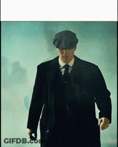 Man In Suit And Hat Walking In Foggy Room GIF