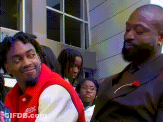 Man In Suit And Man In Red Jacket With Crowd GIF