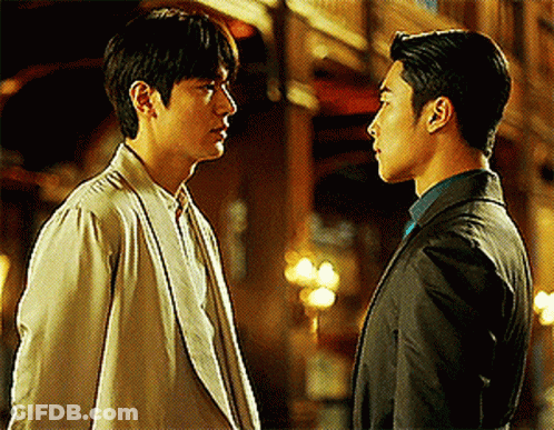 Man In Suit And Man In White Jacket Look At Each Other GIF
