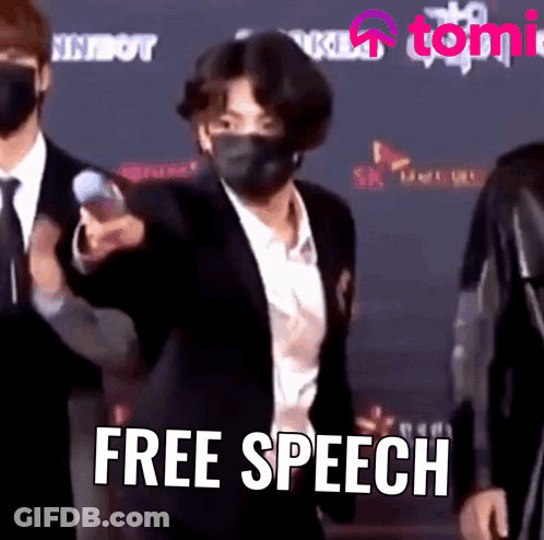 Man In Suit And Mask Standing In Front Of Free Speech Sign GIF