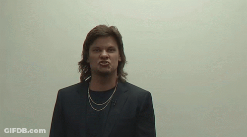 Man In Suit And Necklace Making Angry Face GIF