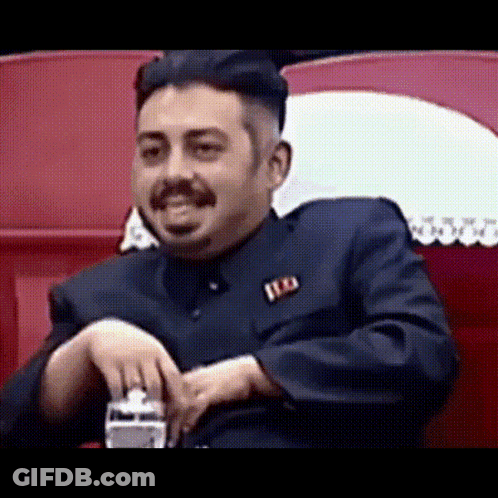 Man In Suit And Orange Tie Making A Face GIF