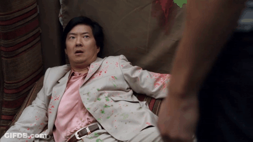 Man In Suit And Pink Shirt Lying Down GIF